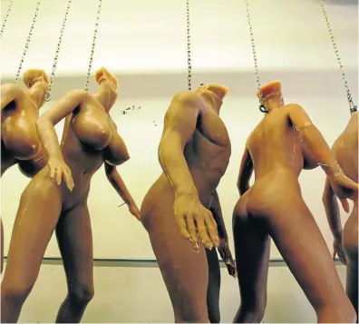  ??  ?? Unfinished silicone RealDoll sex dolls hang from chains in the factory. Picture: Gallo/Getty