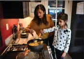  ?? PHOTOS BY JOSE CARLOS FAJARDO — STAFF PHOTOGRAPH­ER ?? Parul Patel gets some help from her daughter Leila, 6, as she cooks pad thai at their Oakland home Dec. 15 before delivering the meals for Community Kitchens.