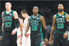  ?? Michael Dwyer / Associated Press ?? The Boston Celtics’ Daniel Theis (27), Terry Rozier (12) and Marcus Morris (13) walk to the bench during a timeout in the second half against the Los Angeles Clippers, in Boston, on Feb. 9. The Celtics were expected to challenge the Warriors for the NBA crown, and that could still happen though right now they’re looking up at Milwaukee and Toronto in the East.