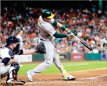  ?? AP PHOTO BY DAVID J. PHILLIP ?? Oakland Athletics' Ryon Healy (25) hits a grand slam as Houston Astros catcher Brian Mccann reaches for the pitch during the sixth inning of a baseball game Tuesday, in Houston.