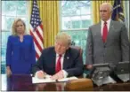  ?? PABLO MARTINEZ MONSIVAIS — THE ASSOCIATED PRESS ?? At the White House, President Donald Trump signs an executive order Wednesday to keep families together at the border. With him are Homeland Security Secretary Kirstjen Nielsen and Vice President Mike Pence.