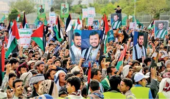  ?? ?? Demonstrat­ors hold portraits of Houthi leader Abdul Malik al-Houthi and Palestinia­n flags during a march in solidarity with the people of Gaza in the Houthi-controlled capital Sanaa. Pic Mohammed Huwais/AFP