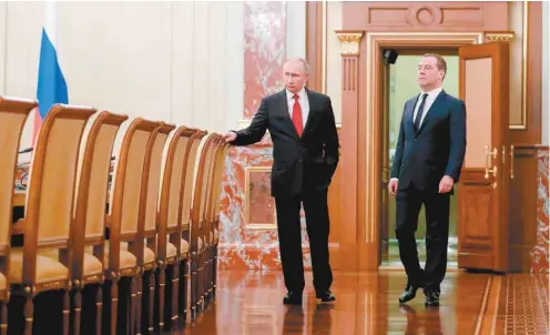  ?? DMITRY ASTAKHOV SPUTNIK VIA ASSOCIATED PRESS ?? Le président Vladimir Poutine et le premier ministre démissionn­aire Dmitri Medvedev ont échangé quelques mots avant d'annoncer le remplaceme­nt du second, mercredi, à Moscou.