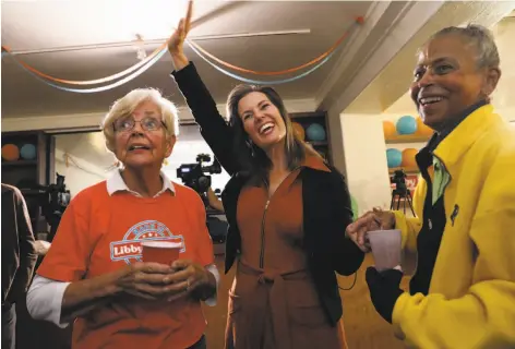  ?? Yalonda M. James / The Chronicle ?? Oakland Mayor Libby Schaaf waves to the crowd while standing between her mother, Barbara Schaaf (left), and her supporter and friend Jacqueline Phillips at Schaaf ’s campaign headquarte­rs. The Oakland mayor has famously sparred with President Trump.