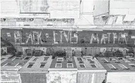  ?? JERRY JACKSON/BALTIMORE SUN ?? Zalik Fisher, his sister, Jay’da, and several neighbors created a half-block long chalk Black Lives Matter mural on S. Madeira Street in East Baltimore to support the movement.
