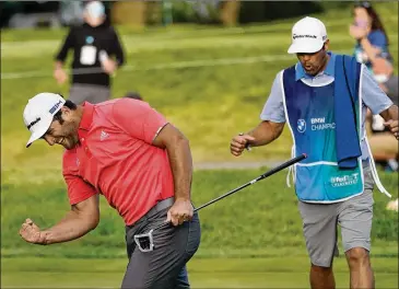  ?? ASSOCIATED PRESS ?? Jon Rahm (left) and caddie Adam Hayes celebrate (and exhale) after Rahm makes his putt on the first playoff hole of Sunday’s final round at the BMW Championsh­ip at Olympia Fields Country Club in Olympia Fields, Ill.
