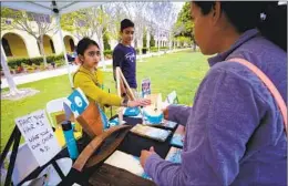  ?? ?? Tvisha Bhardwaj, 11, and her brother, Vihaan, 12, sell one of their handcrafte­d resin artworks to Amanda Malicki at the business fair.