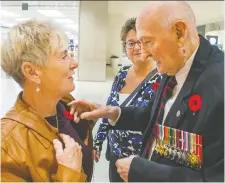  ?? WAYNE CUDDINGTON ?? Second World War veteran Art Boudreau, 99, sells poppies to Anne Miskelly, left, and Sheila Cauley at Bayshore Shopping Centre.