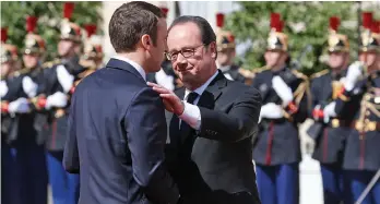  ?? — AP ?? New French President Emmanuel Macron bids farewell to former French President Francois Hollande after the inaugurati­on ceremony at the Elysee palace in Paris on Sunday.