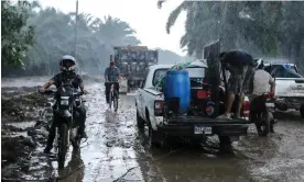  ?? Photograph: Wendell Escoto/AFP/Getty Images ?? Residents leave their homes in the Yoro department of Honduras on Saturday before the arrival of tropical storm Julia, which has since strengthen­ed to a hurricane and is heading towards Nicaragua.