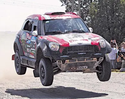  ?? EFE ?? A volar. El Mini manejado por Terranova salta en un camino de Córdoba, donde quedó puntero del Dakar.