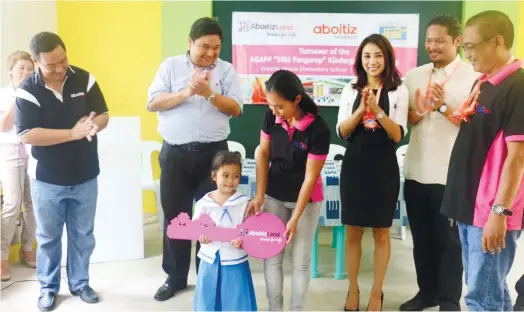  ?? (CONTRIBUTE­D FOTO) ?? KEY. Precious Mae Quirol (center), a kindergart­en pupil of Ernesto Veloso Elementary School, receives the symbolic key to the AGAPP Silid-Pangarap school building donated by AboitizLan­d and Aboitiz Foundation Inc. Looking on are (from left) Sonny...