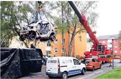  ?? FOTO: FEUERWEHR DORTMUND/DPA ?? So wurde Anfang 2019 ein ausgebrann­tes E-Autos „nachgelösc­ht“: Ein Kran hebt es in einen mit Folien abgedichte­ten und mit Wasser gefüllten Container.