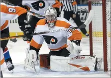  ?? SETH WENIG — THE ASSOCIATED PRESS ?? Philadelph­ia Flyers goaltender Carter Hart itches the puck during the second period of the NHL hockey game against the New York Rangers on Sunday in New York.