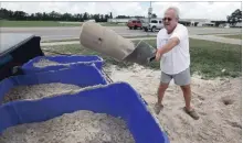  ?? ROGELIO V. SOLIS THE ASSOCIATED PRESS ?? George Estes tosses sand into storage tubs to take back to his law office in Gulfport, Miss., where he will fill bags. Subtropica­l storm Alberto is making its way slowly through the Gulf of Mexico.