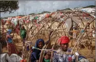  ?? ?? A Somali man and his wife who fled drought-stricken areas build the frame of a makeshift shelter June 4 at a camp on the outskirts of Mogadishu.