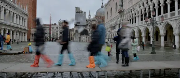  ?? (foto archivio) ?? Sulle passerelle Turisti alle prese con l’acqua alta, in piazza San Marco a Venezia. Il livello ha raggiunto il metro e 19 centimetri