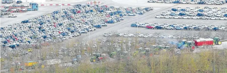  ?? ?? Una fila de tractores ocupa una de las carreteras de acceso al polígono de Landaben. Al fondo, la campa de Volkswagen Navarra. La fotografía es de ayer por la mañana.