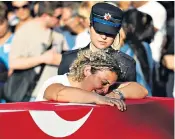 ??  ?? A relation mourns over a policeman’s coffin in Marmaris last night