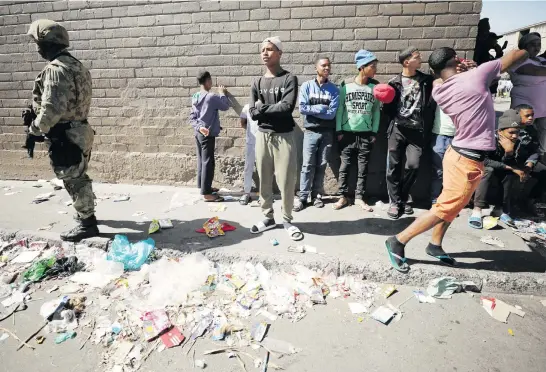  ?? Picture: Reuters ?? WAITING. Residents of Hanover Park near a pile of rubbish during a visit by President Cyril Ramaphosa to the crime-ridden area to launch the new Anti-Gang Unit in Cape Town yesterday.