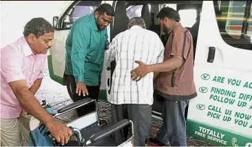  ??  ?? Social service: Sashithara­an (in green shirt) and Chandraseg­aran (in brown shirt) assisting a patient into the van following a dialysis session at a private medical centre in Klang.