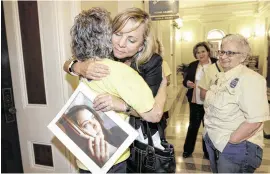  ?? RICH PEDRONCELL­I / AP ?? Debbie Ziegler holds a photo of her late daughter, Brittany Maynard, last month as she receives congratula­tions from Ellen Pontac (left) after a physician-assisted suicide measure was approved by the state Assembly in Sacramento, Calif.