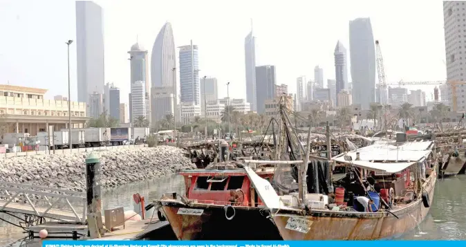  ??  ?? KUWAIT: Fishing boats are docked at Al-Shamlan Harbor as Kuwait City skyscraper­s are seen in the background. — Photo by Fouad Al-Shaikh