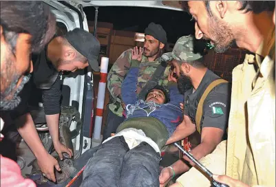  ?? ARSHAD BUTT / ASSOCIATED PRESS ?? Volunteers and police officers rush an injured man to a hospital in Quetta, Pakistan, on Tuesday, after militants wearing suicide vests stormed a police academy.