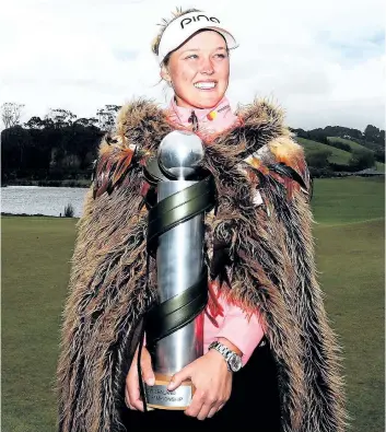  ?? GETTY IMAGES ?? Brooke Henderson, of Smiths Falls, Ont., poses wearing a Maori cloak and holds the winner’s trophy after winning the inaugural New Zealand Women’s Open in October in Auckland, New Zealand.