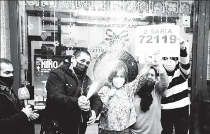  ?? ?? Lottery shop owners and winners celebrate a Second prize-winning ticket in Spain’s Christmas Lottery “El Gordo” (The Fat One) in Basauri, Spain, December 22, 2021. (REUTERS/Vincent West photo)