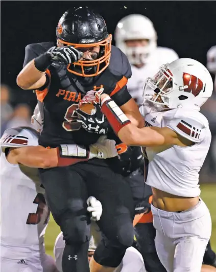  ?? STAFF PHOTO BY ROBIN RUDD ?? South Pittsburg’s Garrett Raulston tries to surge forward with two Whitwell defenders attached to him during a regular-season meeting at South Pittsburg on Oct. 13, 2017. The host Pirates won 21-14 and also beat the Tigers in the playoffs. They meet again tonight.