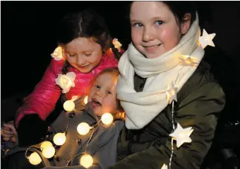  ?? Photos by Declan Malone ?? Emer, Katie and Aoife Aherne from Ballyriste­en covered in smiles and lights at Féile na Soilse on Sunday evening in Dingle. RIGHT: Ellie and Seán Ó Mainín.