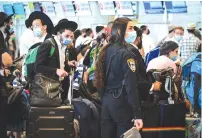  ?? (Avshalom Sassoni/Flash90) ?? POLICE OFFICERS enforce the COVID-19 regulation­s at BenGurion Airport yesterday.