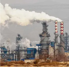  ?? Olivia Zhang/Associated Press ?? Smoke and steam rise from a coal processing plant in Hejin, China, in 2019. The Internatio­nal Energy Agency says companies are not curbing emissions enough.