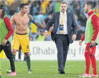  ??  ?? Australia’s Tim Cahill, left, celebrates with coach Ange Postecoglo­u after a win.