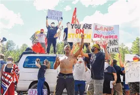  ?? ERIN BORMETT/THE ARGUS LEADER ?? Protesters form a blockade on the highway leading to Mount Rushmore, in Keystone, S.D., in July. Many Native Americans consider the monument featuring the faces of four U.S. presidents a symbol of white supremacy and a desecratio­n to the area known to Lakota people as Paha Sapa, “the heart of everything that is.”