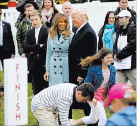  ?? Pablo Martinez Monsivais ?? The Associated Press President Donald Trump and first lady Melania Trump smile after blowing their whistles Monday to start a race at the annual White House Easter Egg Roll on the South Lawn. Also with them is their son Barron Trump, left.