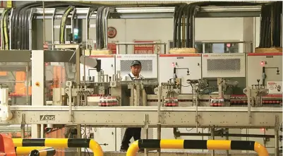  ?? FRIZAL/JAWA POS ?? YANG KEDUA: Pegawai Coca-Cola Amatil Indonesia mengawasi proses produksi setelah peresmian fasilitas produksi ASSP di Pasuruan kemarin.