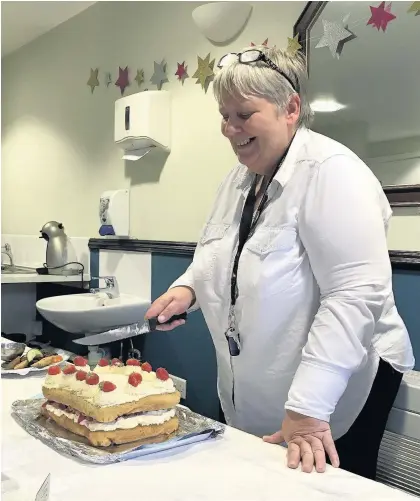  ??  ?? Linda Jenkins, right, general manager at Brocastle Care Home near Bridgend, cuts her cake to mark 30 years in the care sector