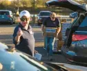  ?? KENDALL WARNER/STAFF ?? Volunteers load boxes into a vehicle during a food distributi­on for about 300 military personnel and families at Langley Air Force Base in Hampton on Nov. 16.