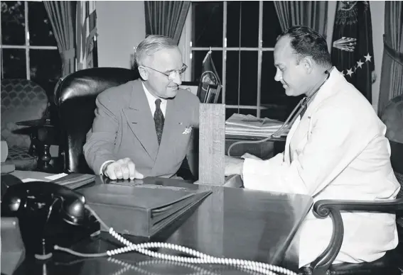  ??  ?? Brigadier Gen. Wallace Harry Graham, right, personal physician of President Harry S. Truman checks his blood pressure in the president's office in Washington. Seventy years ago, before Medicare existed to inspire “Medicare for All,” a Democratic president wrestled with a challenge strikingly similar to what the party’s White House hopefuls face today. Harry Truman, then in his fourth year of pressing for a national health insurance system, parried criticism of his approach in terms that a single-payer health care advocate might use in 2019.