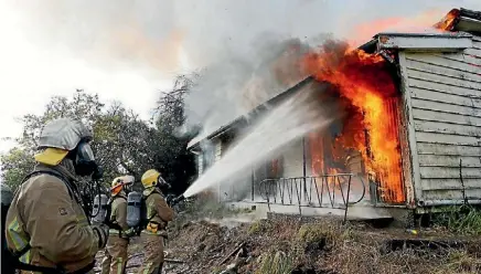  ?? PHOTO: MARTIN DE RUYTER/FAIRFAX NZ ?? Volunteer and rural fire fighters at a house burn training exercise at Lower Moutere.
