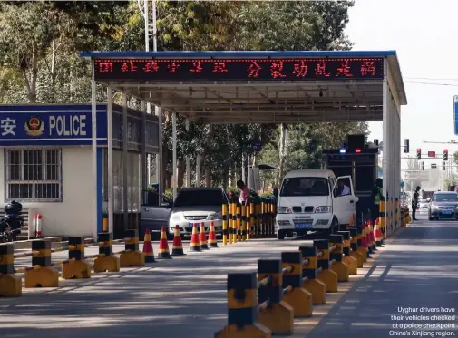  ??  ?? Uyghur drivers have their vehicles checked at a police checkpoint China’s Xinjiang region.