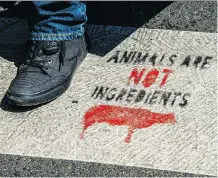  ?? PHILIPPE HUGUEN/AFP/GETTY IMAGES FILES ?? A person walks on a vegan slogan on a crosswalk in Lille, France. More than US$6 billion is tied up in funds focused on environmen­tal, social and governance issues.