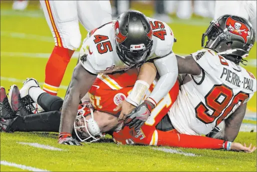  ?? Gregory Bull The Associated Press ?? Patrick Mahomes, center, was chased and harassed by the Buccaneers’ defense the entire game. Devin White (45) and Jason Pierre-paul get a sack on this play.