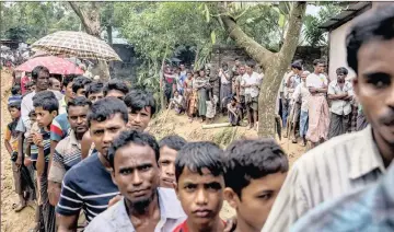  ?? PICTURE: AP ?? PERSECUTED: Rohingya waiting to collect building material for shelter in Bangladesh on Wednesday. With their refugees flooding in from Myanmar to Bangladesh, hunger and illness are soaring in the camps.