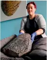  ?? AFP ?? A gallery assistant poses with a Babylonian cuneiform kudurru (boundary stone) at the British museum in London. —