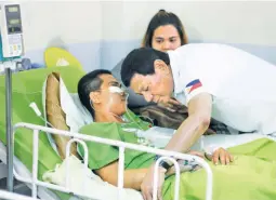  ??  ?? HOSPITAL VISIT – Pfc. Daniel Fabular whispers to President Duterte during the President’s visit to a private hospital in Davao City where Fabular and six other soldiers wounded in recent clashes with communist rebels in Eastern Mindanao are confined....