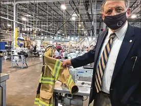  ?? THOMAS GNAU / STAFF ?? John Granby, Lion vice president, government relations and corporate responsibi­lity, shows some of the gear produced at Lion’s 66 Janney Road plant.