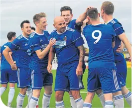  ??  ?? Paul Mcmanus celebratin­g with his Cove team-mates after scoring to make it 2-0.